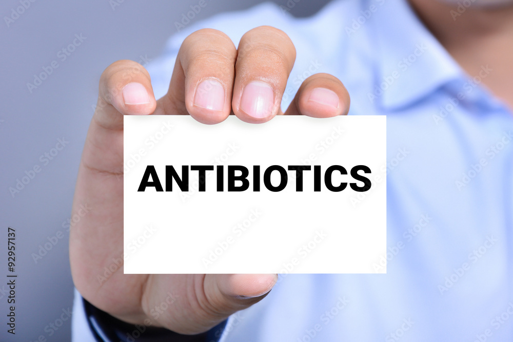 ANTIBIOTICS word on the card shown by a man ANTIBIOTICS word on the card shown by a man