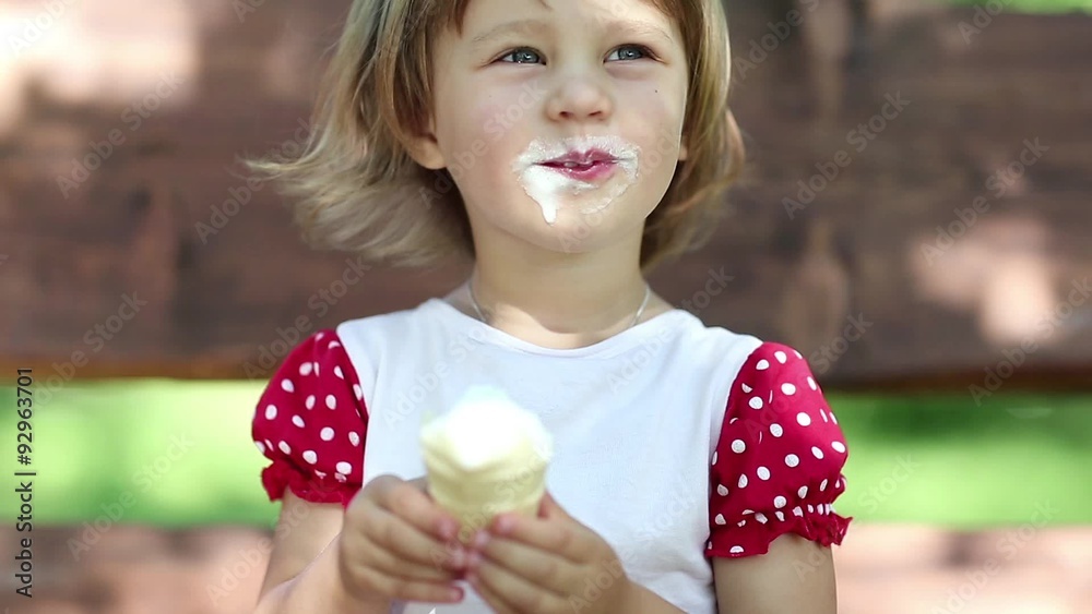 Little girl sits on the swing bench and eats ice cream Little girl sits on the swing bench and eats ice cream