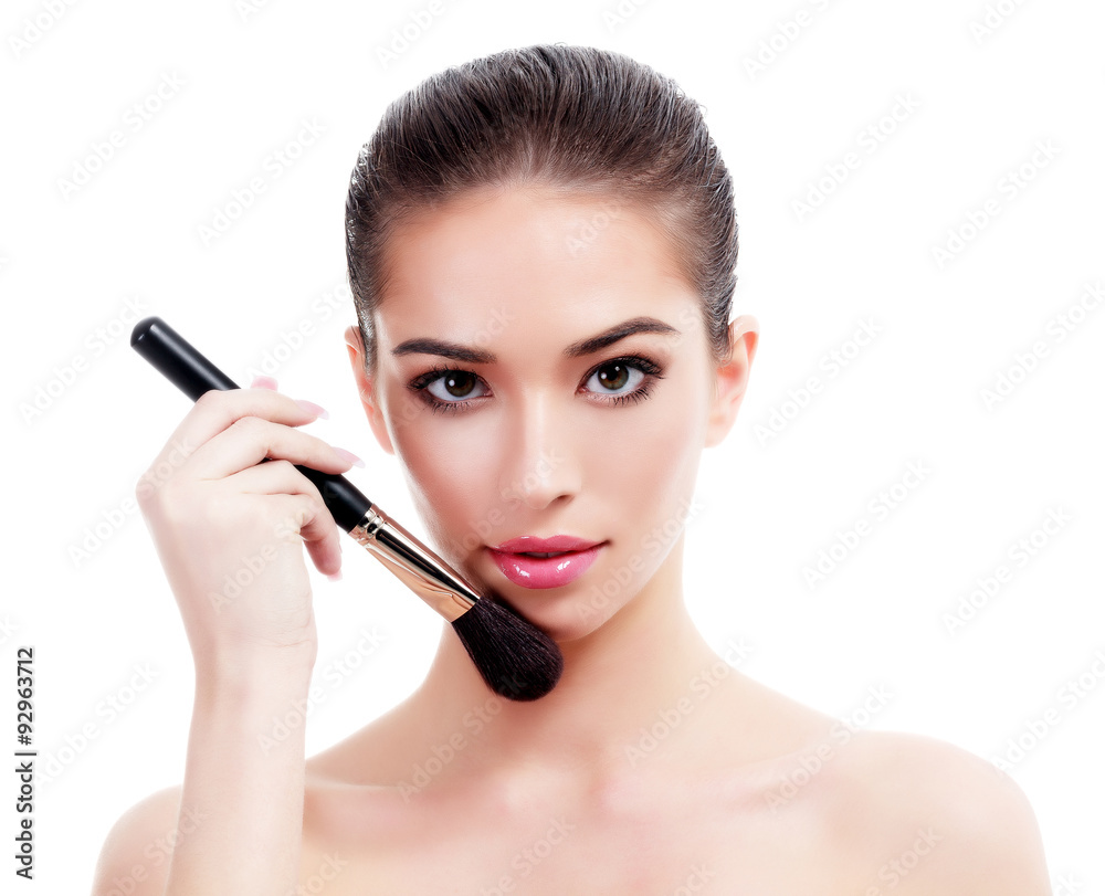 Pretty woman with a makeup brush, isolated on white Pretty woman with a makeup brush, isolated on white