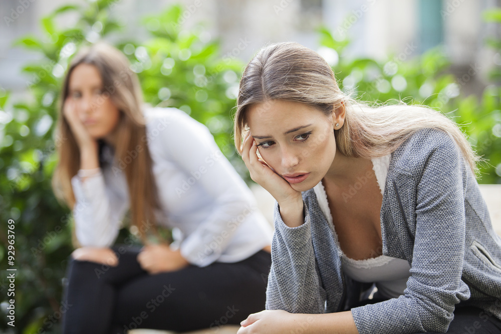 Portrait of young woman and friend outdoor on street having problems. Depression concept Portrait of young woman and friend outdoor on street having problems. Depression concept