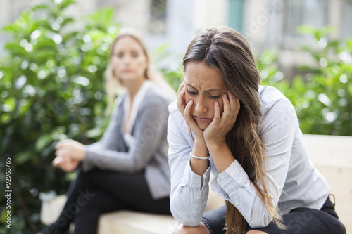 Portrait of young woman and friend outdoor on street having problems. Depression concept