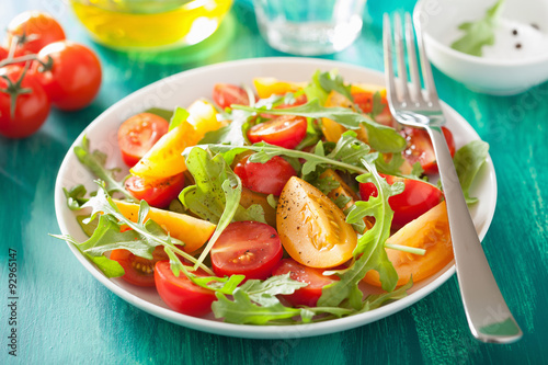 tomato salad with arugula over green background