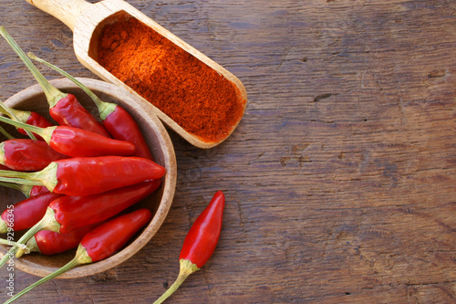 Chilischoten in Schale und Pulver auf Gewürzschaufel