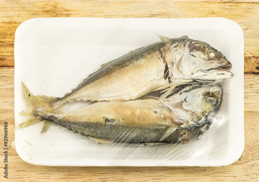 mackerel steamed in foam white tray on wooden background mackerel steamed in foam white tray on wooden background