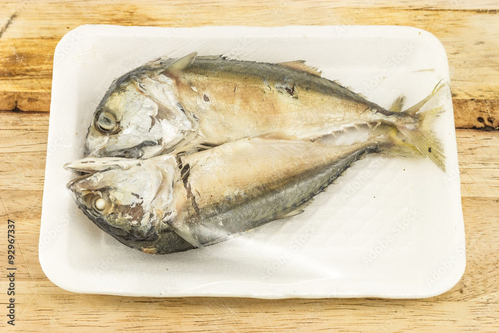 mackerel steamed in foam white tray on wooden background mackerel steamed in foam white tray on wooden background