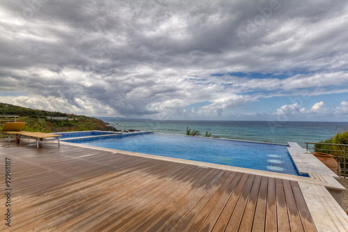 Dramatic view of Swimming Pool and Deck overlooking sea on a cloudy day in Pomos, Cyprus
