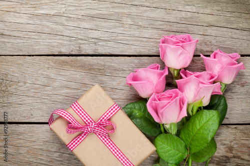 Fototapeta Naklejka Na Ścianę i Meble -  Pink roses and valentines day gift box over wooden table