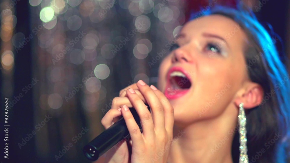Beautiful teenage girl with long blowing hair singing karaoke Beautiful teenage girl with long blowing hair singing karaoke