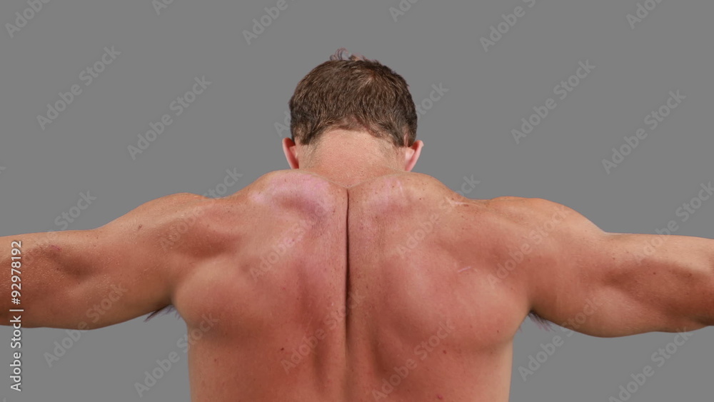 Muscular man flexing his back muscles Muscular man flexing his back muscles