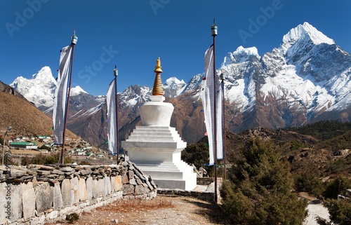 White stupa, prayer flags and himalayas photo