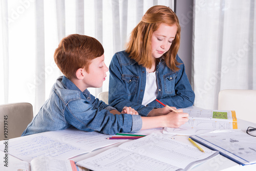 sister is helping brother with homework