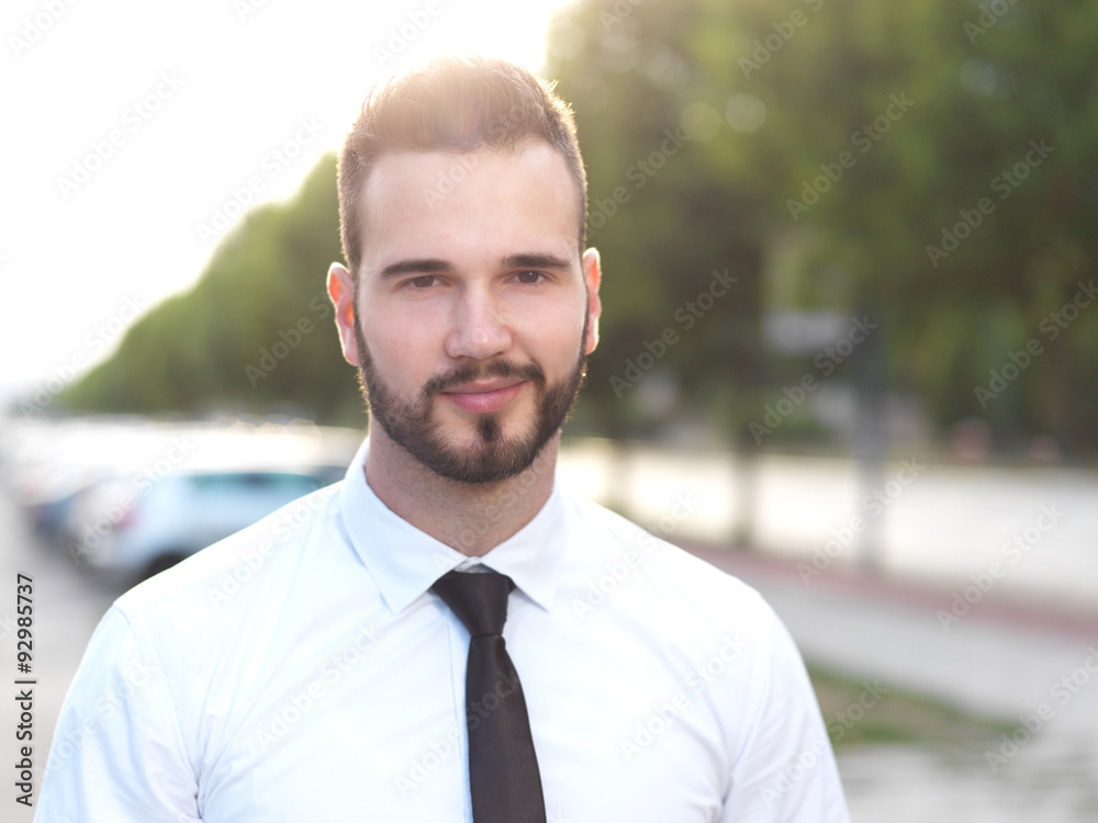 Friendly and smiling handsome businessman looking confidently Friendly and smiling handsome businessman looking confidently