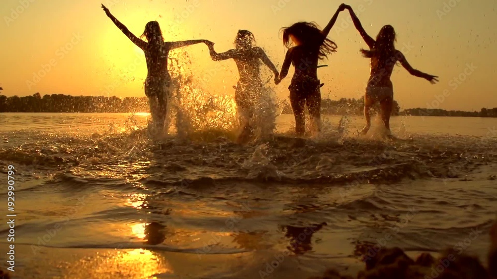 Girls running and playing in water at the beach