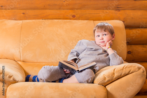 Kid sitting on sofa with a book