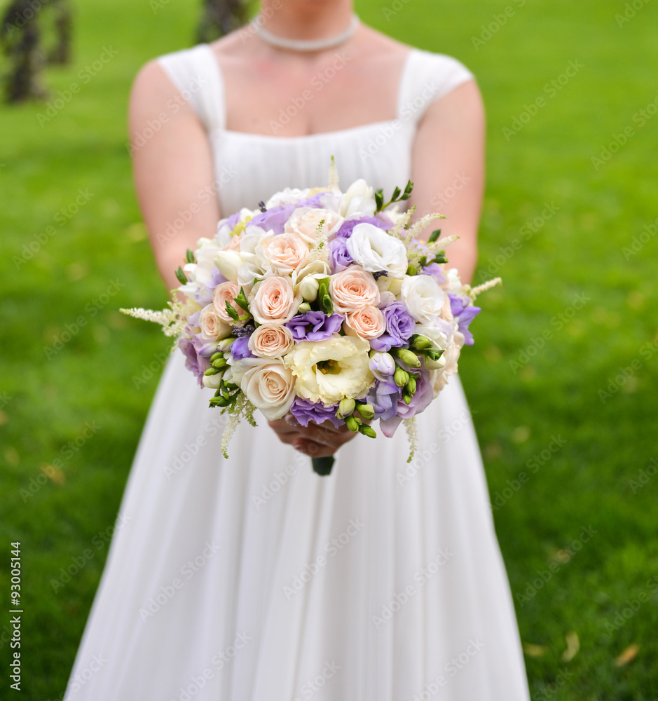 Bride holding wedding bouquet with colorful flowers Bride holding wedding bouquet with colorful flowers