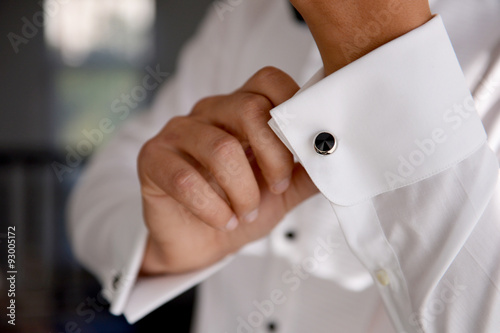 close up of a hand man how wears white shirt and cufflink photo