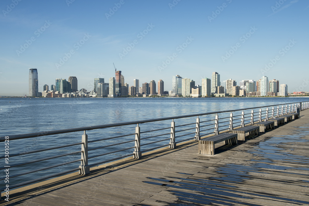 City skyline of Jersey City and Hoboken New Jersey from a pier  in New York City across the waters of the Hudson River