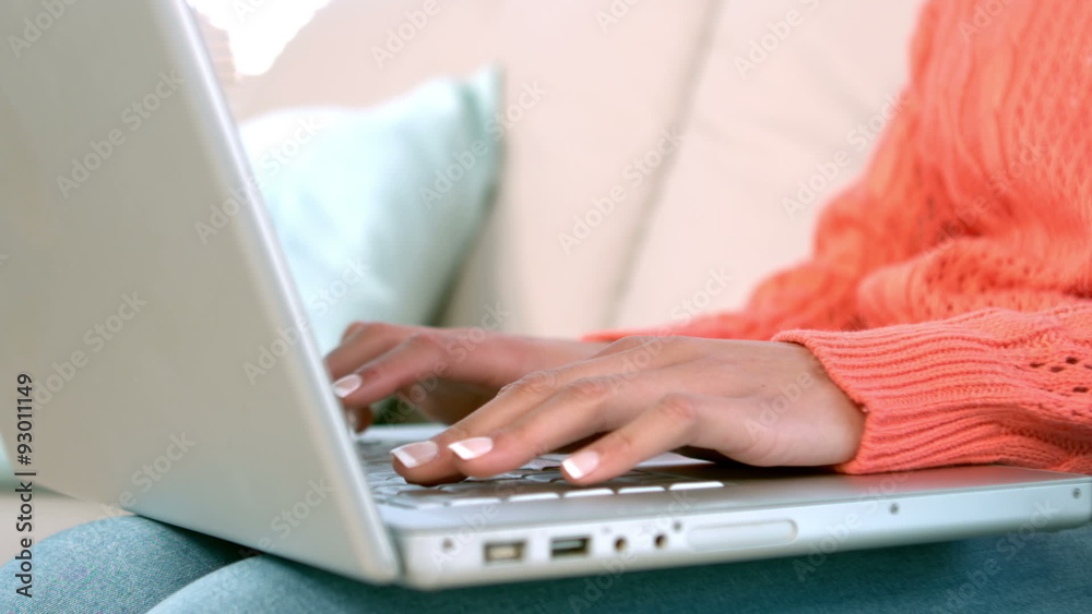 Woman using laptop on sofa at home Woman using laptop on sofa at home