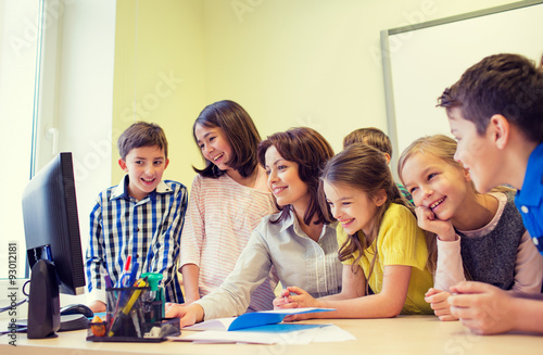 group of kids with teacher and computer at school