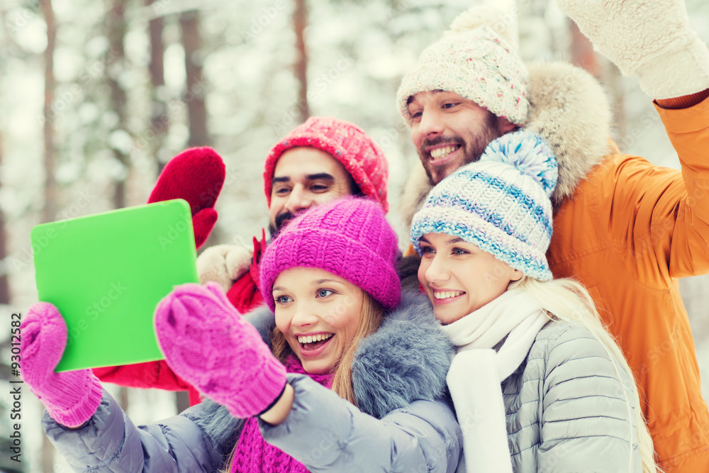 smiling friends with tablet pc in winter forest smiling friends with tablet pc in winter forest