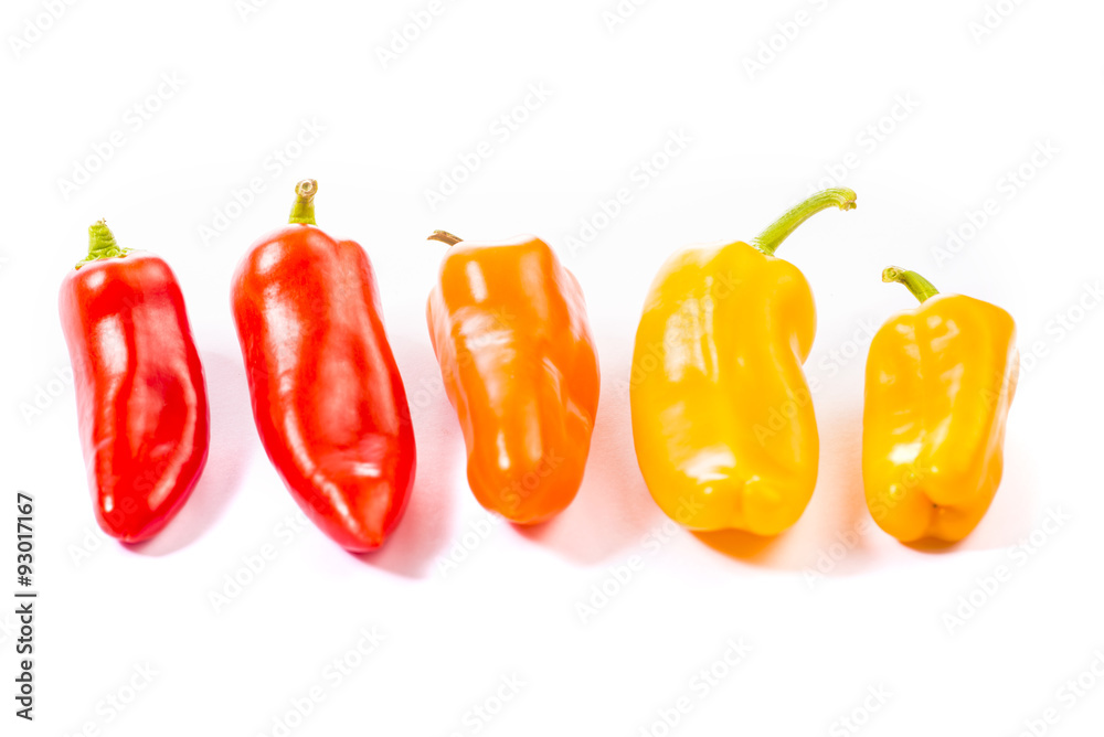 Red, yellow and orange pepper on white background