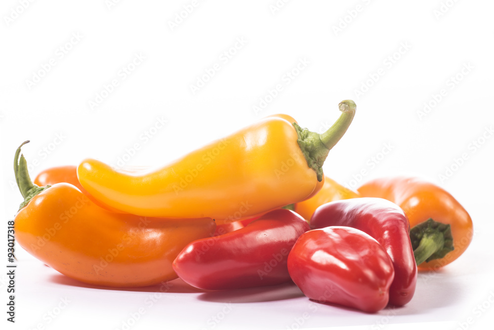 Red, yellow and orange pepper on white background
