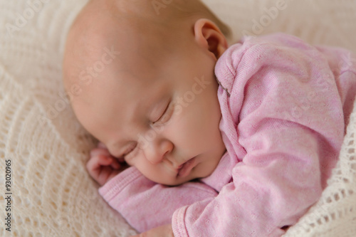 Nahaufnahme neugeborenes Baby schläft zufrieden auf weißer Decke