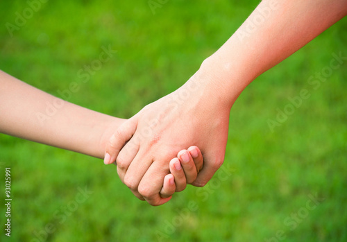 Mother holding a hand of his son in summer day outdoors © nata777_7