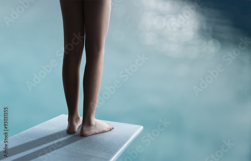 Young boy or girl is standing on a divingboard photo