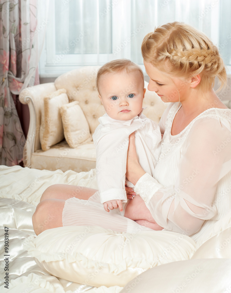 Mother and baby playing and smiling. Happy family.Home interior. Mother and baby playing and smiling. Happy family.Home interior.