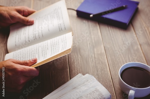 Person holding book at desk