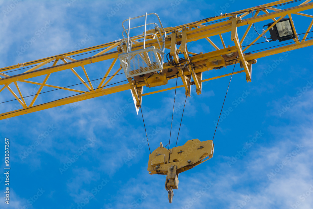 Crane and workers at construction site against blue sky. Crane and workers at construction site against blue sky.