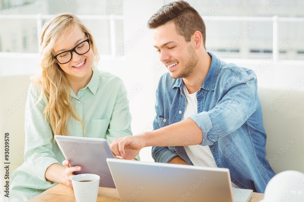 Smiling woman discussing with man while holding digital tablet Smiling woman discussing with man while holding digital tablet