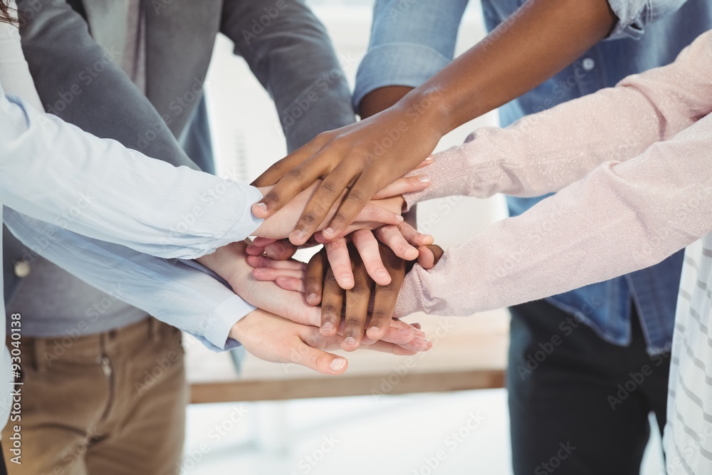Mid section of business team putting their hands together Mid section of business team putting their hands together