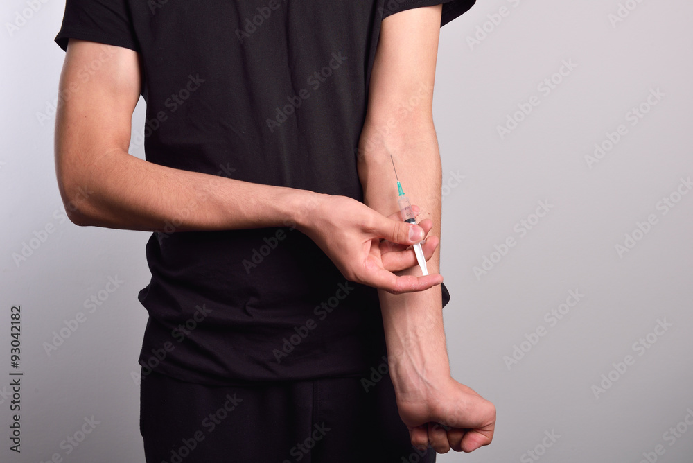Hand of the narcotist preparing to inject drugs