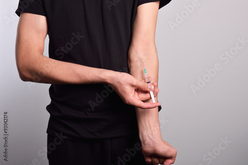 Hand of the narcotist preparing to inject drugs