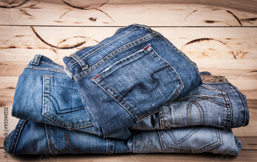 fashionable clothes. pile of jeans on a wooden background