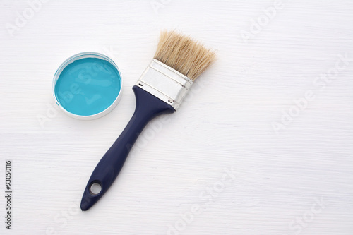 Clean paintbrush and blue paint on white board