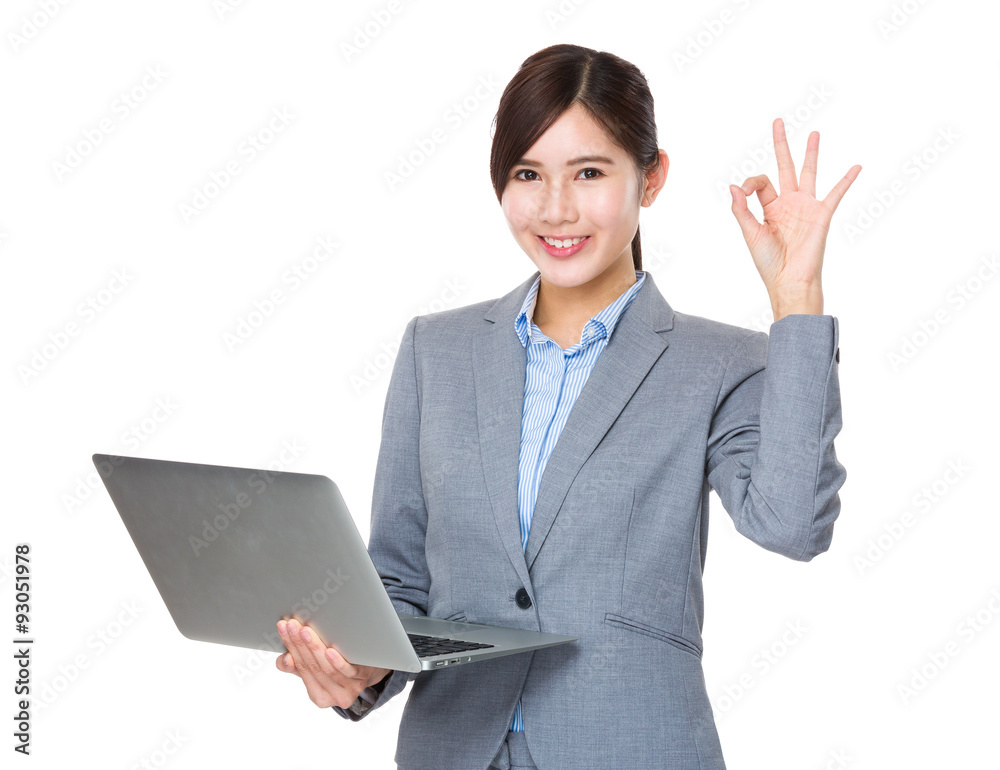 Young Businesswoman use of the notebook computer and ok sign ges Young Businesswoman use of the notebook computer and ok sign ges