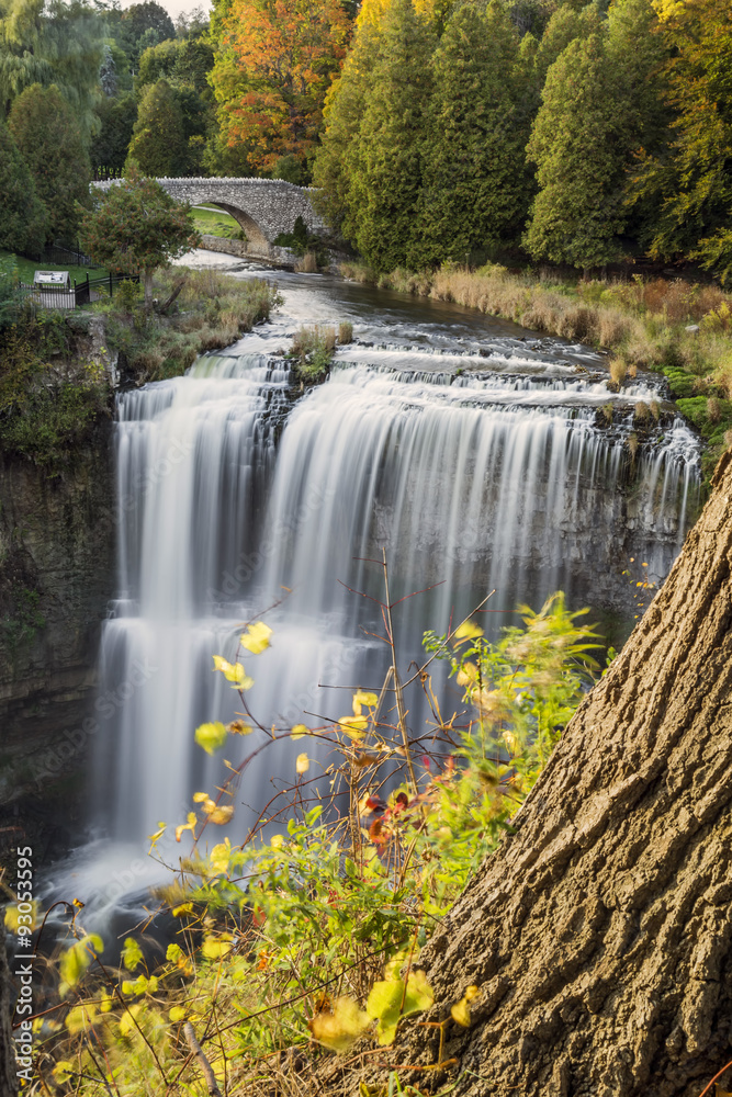 Websters Falls in autumn with stone bridge.