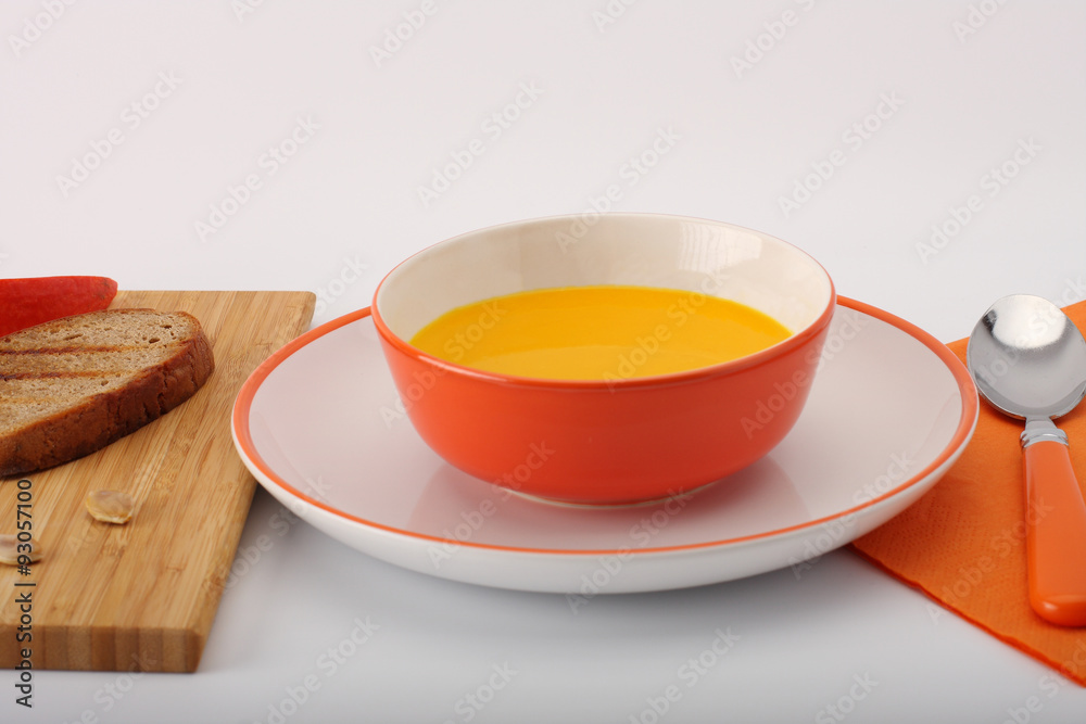 bowl of pumpkin hokkaido soup with bread on white bowl of pumpkin hokkaido soup with bread on white