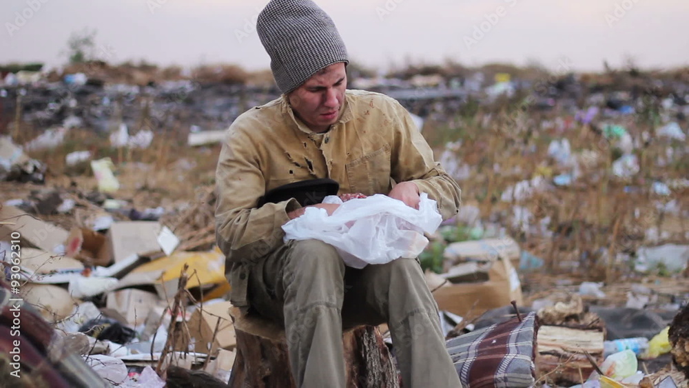 dirty homeless man sits on a stump in the trash and eat dirty homeless man sits on a stump in the trash and eat