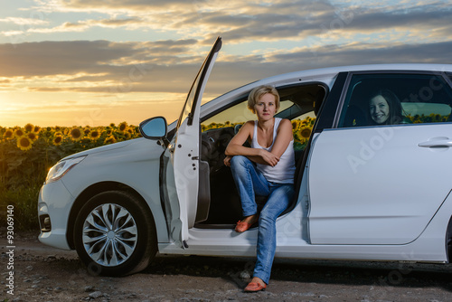 Pretty blond woman sitting waiting in her car