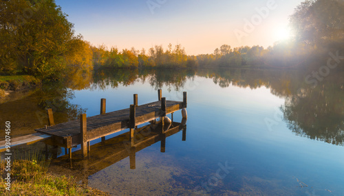 Fotografia Wooden Jetty on a Becalmed Lake at Sunset