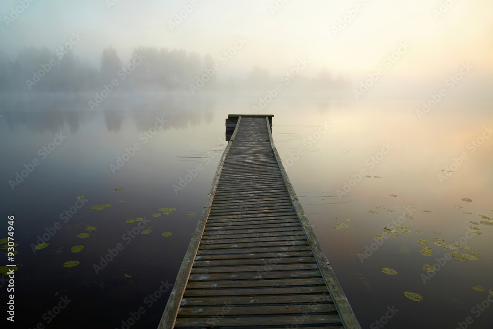 Wooden boat dock on the mysty lake. Finland