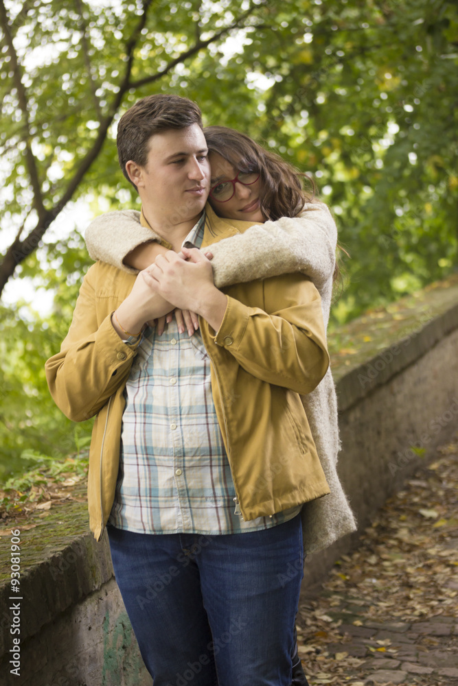 Fototapeta premium Young couple, boyfrind hugging girlfriend. Girlfriend looking to