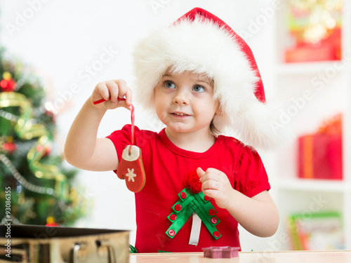 kid girl in Santa hat holdi...