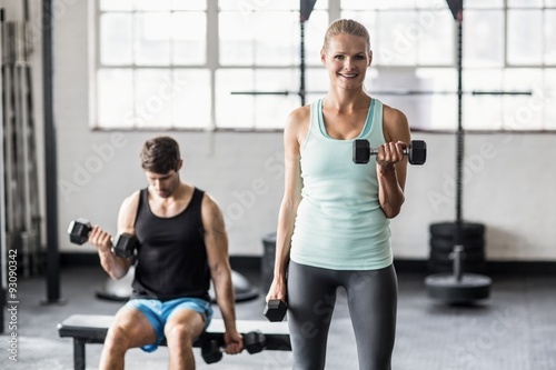 Sporty couple exercising with dumbbells