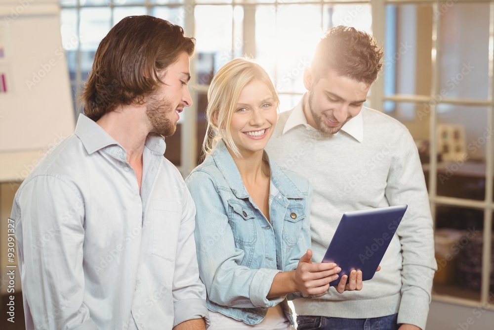 Businesswoman holding laptop standing with male colleagues Businesswoman holding laptop standing with male colleagues