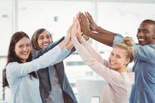 Portrait of smiling business team giving high five 